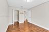 Room featuring wood-finish flooring, neutral wall paint, and a built-in closet with shelving