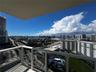 Private balcony featuring a white aluminum railing and panoramic cityscape, waterway, and coastal scenery