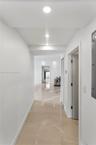 Hallway featuring polished concrete flooring, recessed lighting, and louvered closet doors