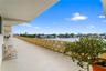 Expansive covered balcony featuring a geometric latticework railing and solid surface flooring with an open exposure to the water