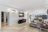 Polished stone flooring, recessed lighting, wall-mounted sconces, and large windows with outdoor scenery