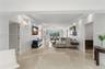 Polished stone flooring, recessed lighting, crown molding, and large picture windows featuring exterior greenery