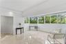 Polished stone flooring, expansive wrap-around windows, and recessed lighting