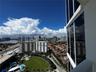 Floor-to-ceiling glass paneling and exterior window wall featuring an expansive perspective of the surrounding cityscape, coastline, and urban infrast