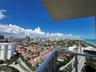 Private balcony with metal railing overlooking the coastal cityscape and shoreline