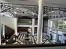 Grand foyer featuring vaulted structural steel ceiling trusses, floor-to-ceiling windows, polished stone flooring in a geometric pattern, and prominen