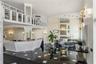 Two-story atrium featuring polished tile flooring with inlaid geometric accents, built-in reception desk, mezzanine level with open shelving, paneled 