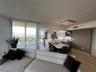 Open-concept kitchen featuring an oversized island with stone-finish countertops, flat-panel cabinetry, built-in stainless steel appliances, and floor