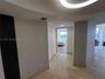 Curved ceiling architecture featuring a circular recessed lighting fixture, stone flooring, and vertical dark-toned decorative wall paneling