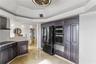 Kitchen featuring custom dark-toned cabinetry, stainless steel double wall oven, integrated microwave, built-in refrigerator, and a tray ceiling