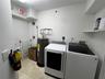 Utility room featuring stone-tile flooring and built-in shelving