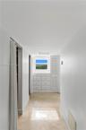 Built-in cabinetry featuring multiple drawers and a louvered door, integrated window, and polished stone-finish flooring