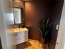 Floating white vanity with two drawers, rectangular basin, matte black faucet, wall-mounted arched mirror, and stone flooring