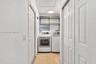 Laundry room featuring tile flooring, white panel doors, metal wire shelving, and overhead flush-mount lighting