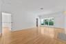 Open-concept living space featuring wood-finish flooring, recessed lighting, and large windows with integrated blinds