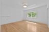 Room featuring wood-finish flooring, a contemporary geometric flush-mount light fixture, and a single-pane window