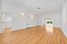 Living area featuring wood-finish flooring, a decorative fireplace, recessed ceiling lighting, wall-mounted sconces, and crown molding