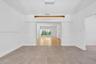 Large-format tile flooring, recessed wall niches, and a linear wood-finish pendant light fixture