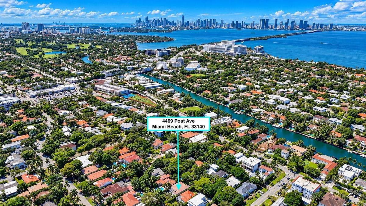 Aerial perspective of a residential property situated in a coastal environment featuring dense mature canopy, proximity to a waterway, and a coastal c