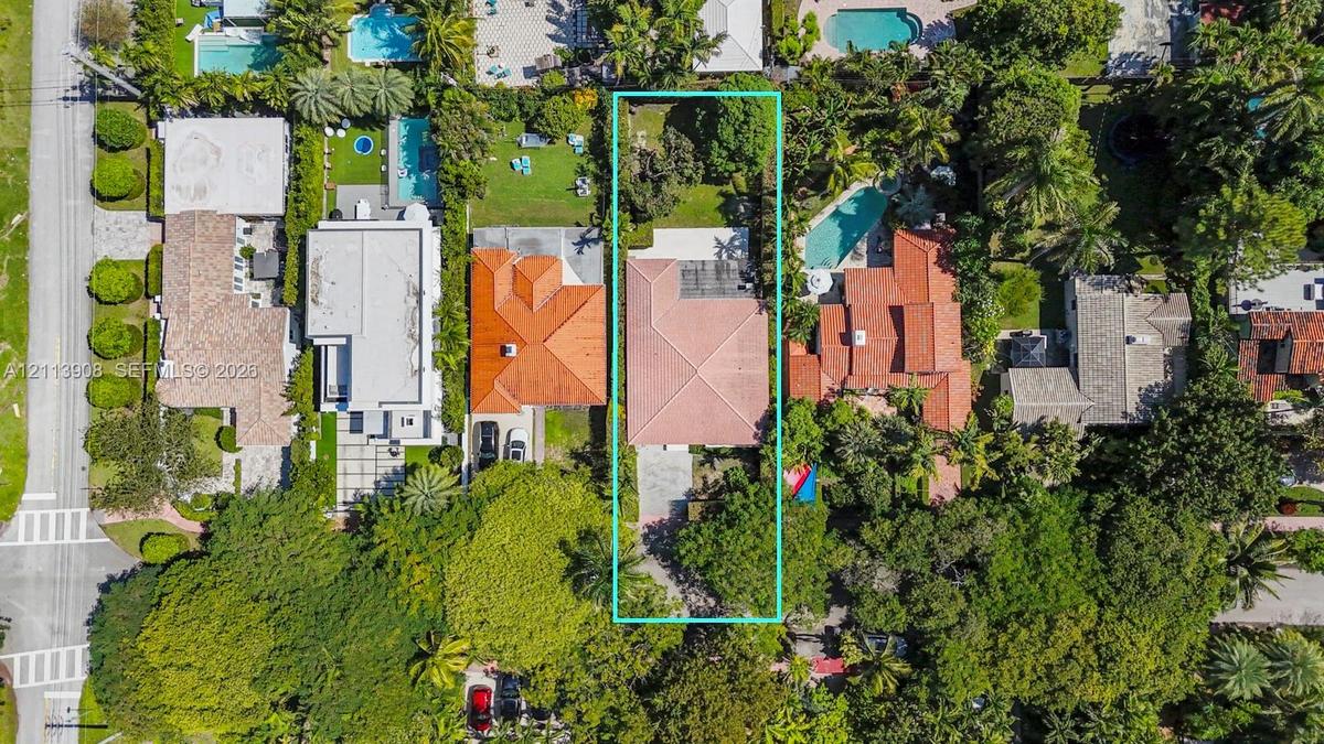 Aerial perspective featuring a lot with mature landscaping, an expansive rear lawn, and a multi-pitched roofline
