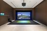 Recreation room featuring floor-to-ceiling wood-paneled walls, large-format tile flooring, a recessed ceiling projector, and a built-in digital sports