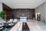 Grand lobby featuring polished stone flooring, custom wood-paneled feature wall with integrated accent lighting, built-in stone reception desk, and st