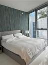 Floor-to-ceiling windows, textured accent wall, and polished tile flooring
