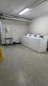 Dedicated laundry room featuring vinyl tile flooring and overhead fluorescent lighting