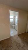 Bathroom featuring tile flooring, a built-in vanity cabinet with countertop, an integrated commode, and a window with a horizontal grid pattern