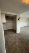 Alcove area featuring built-in cabinetry, overhead shelving, wall-mounted lighting fixtures, and wall-to-wall carpeting