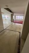 Polished stone flooring with decorative inlay borders, expansive windows, and mirrored support columns