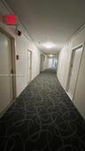 Interior hallway featuring patterned carpeting, recessed ceiling lighting, and solid-core doors