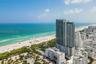 High-rise tower featuring glass-paneled facades, expansive exterior balconies, and direct proximity to the oceanfront