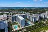 Aerial perspective featuring multiple high-rise structures, landscaped grounds, and multiple outdoor swimming pools