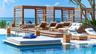 Swimming pool with a raised wood-finish deck, tiered wooden cabanas, and integrated metal railing