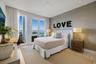 Floor-to-ceiling windows, textured accent wall, recessed lighting, and wood-finish flooring