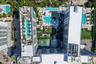 Aerial perspective of a multi-structure complex featuring multiple rectangular swimming pools, hardscaped recreation areas, integrated green space, an