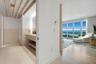 Light-filled interior featuring floor-to-ceiling windows, wood-finish flooring, exposed ceiling beams, a built-in vanity with under-counter shelving, 