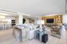 Open-concept space featuring wood-finish flooring, recessed lighting, and custom wood built-in shelving with integrated lighting