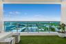 Private balcony featuring synthetic turf surfacing and a glass-paneled railing with metal framing