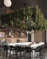 Exposed brick walls, custom built-in wood shelving, and a stone-topped bar counter featuring a prominent overhead suspended planter