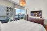 Floor-to-ceiling glass windows, recessed ceiling lighting, and private balcony access