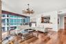 Living area featuring floor-to-ceiling windows, wood-finish flooring, a rustic chandelier, and a built-in pass-through window with a ledge
