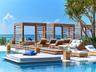 Swimming pool area featuring a stepped wooden deck, custom built-in wood-frame cabanas, and integrated lantern lighting