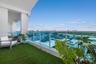 Covered balcony featuring synthetic turf flooring and a glass panel railing