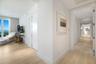 Light-toned wood-finish flooring, recessed ceiling lighting, solid-core interior doors, and floor-to-ceiling glass panel door