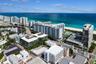 Aerial perspective of a coastal residential district featuring direct oceanfront proximity, sandy beach access, high-rise architecture, and expansive 