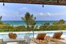 Outdoor terrace featuring a swimming pool with a glass railing and direct ocean exposure