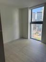Neutral interior space featuring large-format tile flooring, floor-to-ceiling windows, and urban cityscape backdrop