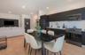 Kitchen featuring matte black flat-panel cabinetry, white subway tile backsplash, light-toned wood-finish flooring, and recessed ceiling lighting